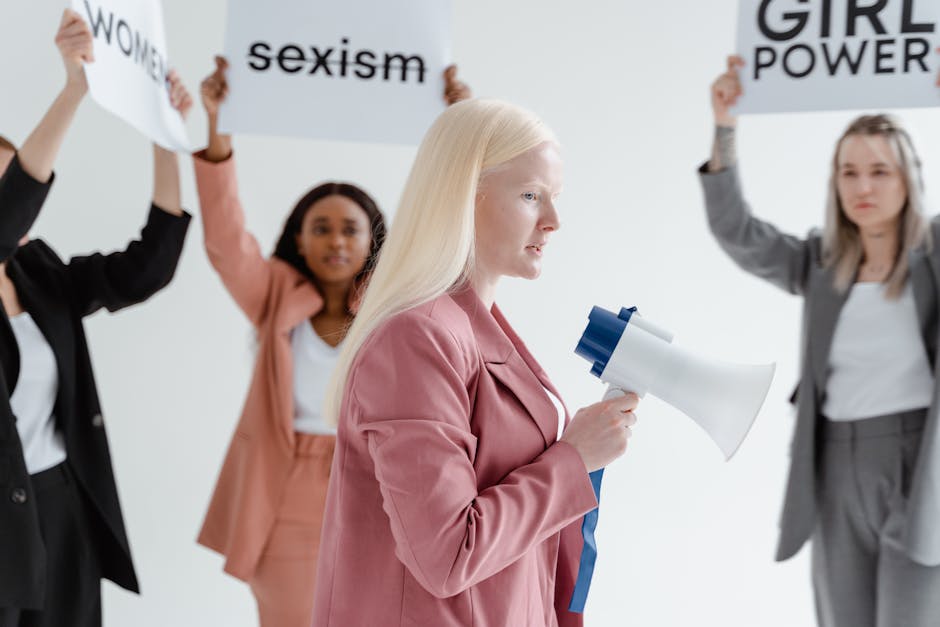 A diverse group of women at a 1960s feminist rally, holding signs with empowering messages and singing together