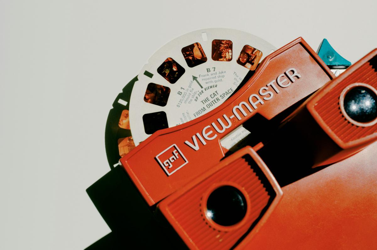 The iconic red View-Master model from 1962 displayed prominently with a selection of colorful reels